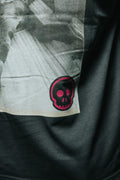 Black t-shirt with a skull patch on a dark background