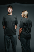 Two people wearing black t-shirts with text on a dark background