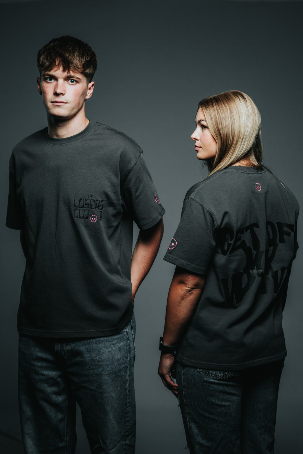Person wearing a black t-shirt with text on the back against a gray background
