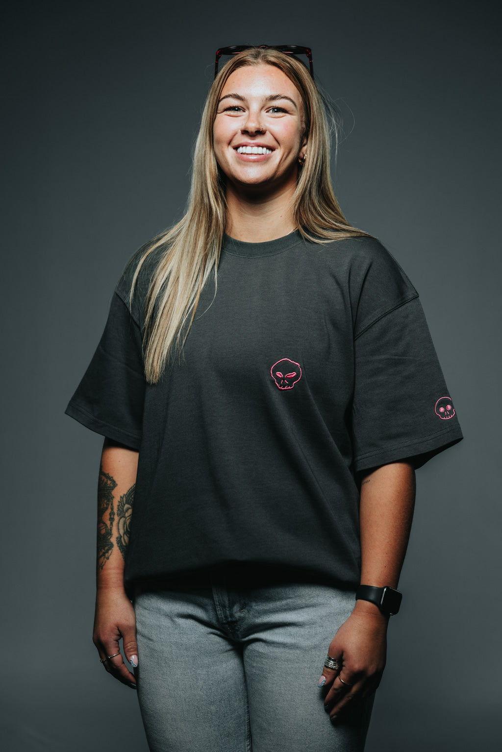 Woman wearing a black t-shirt with a logo on a gray background