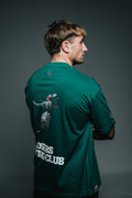 Man wearing a green t-shirt with a design on the back against a gray background